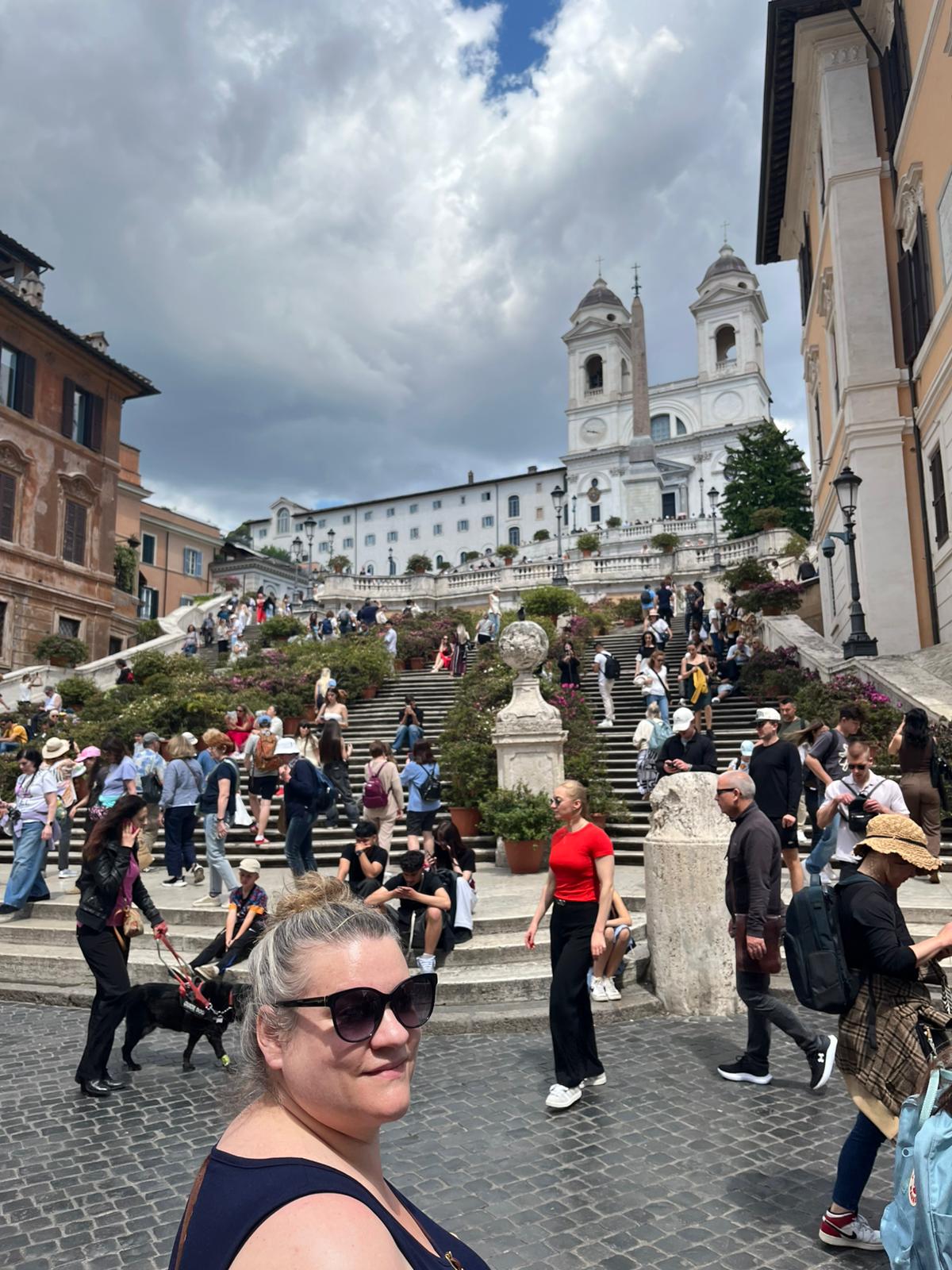People at Spanish Steps, Rome, with Trinità dei Monti church and surrounding historic buildings.