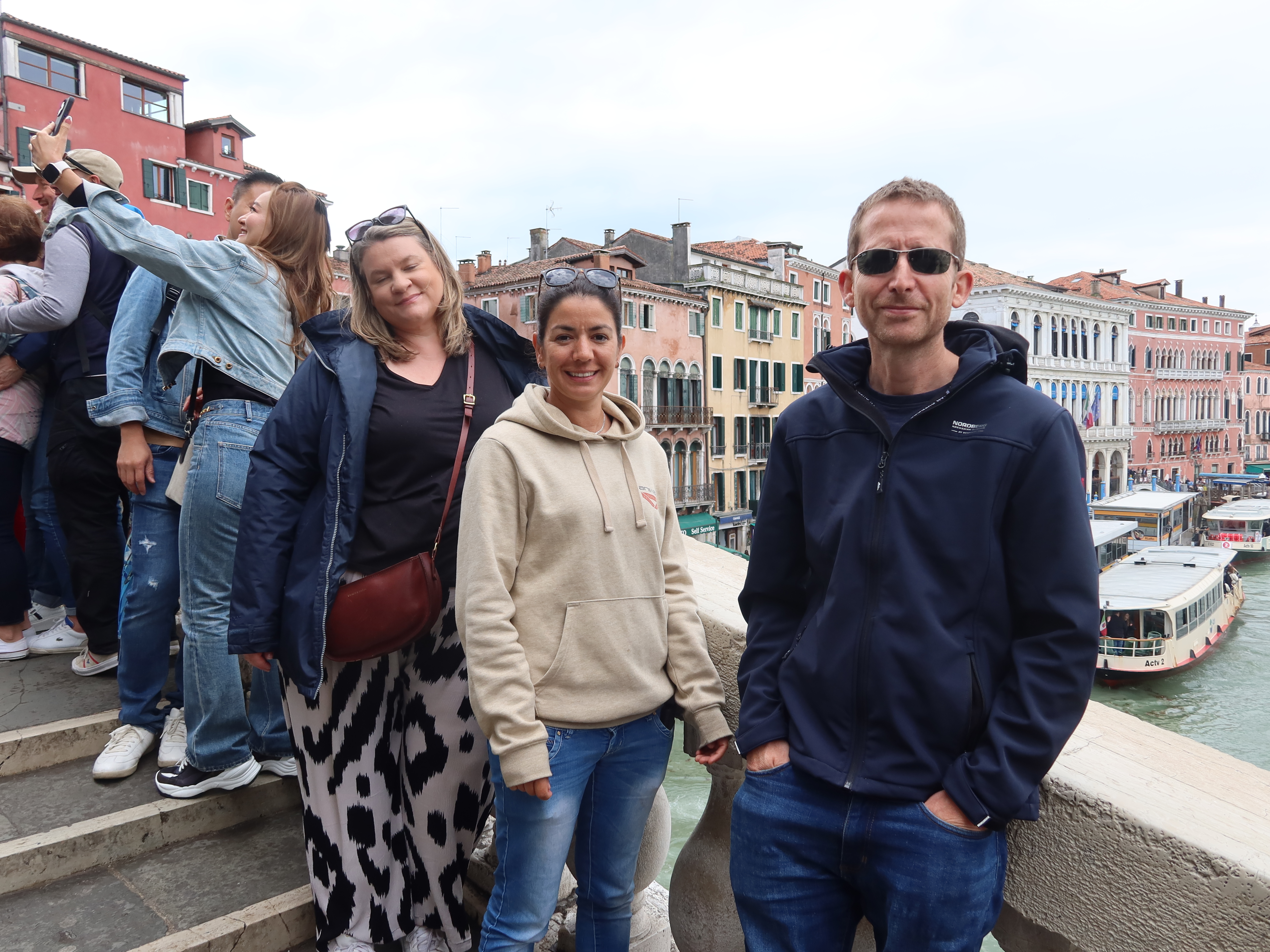 Tourists on Historic European Stairway People on stone stairway with colorful buildings and canal in background, suggesting a tourist spot.