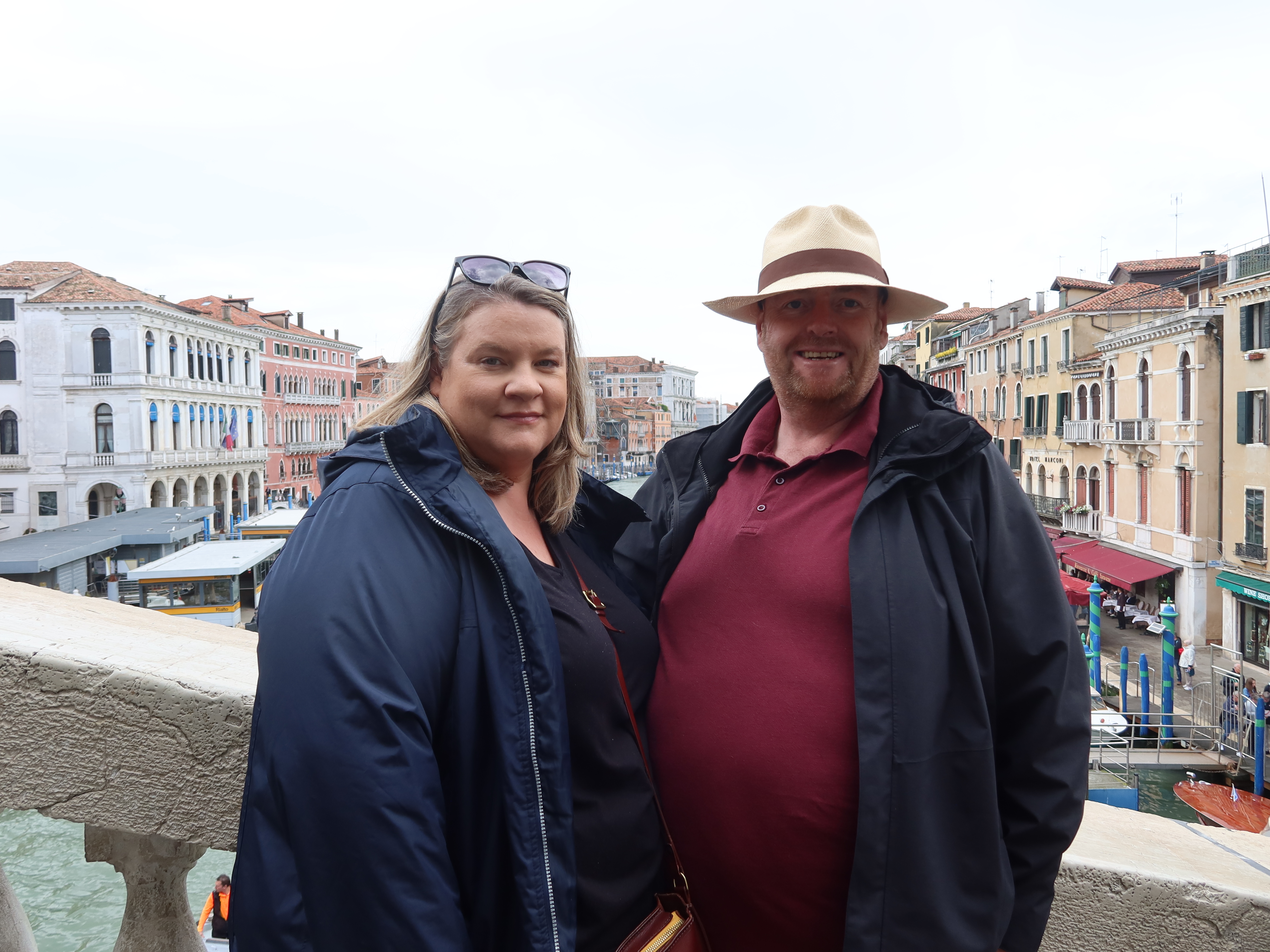 Couple Enjoying Urban Canal View Man and woman on a bridge with canal, historic European buildings in the background.