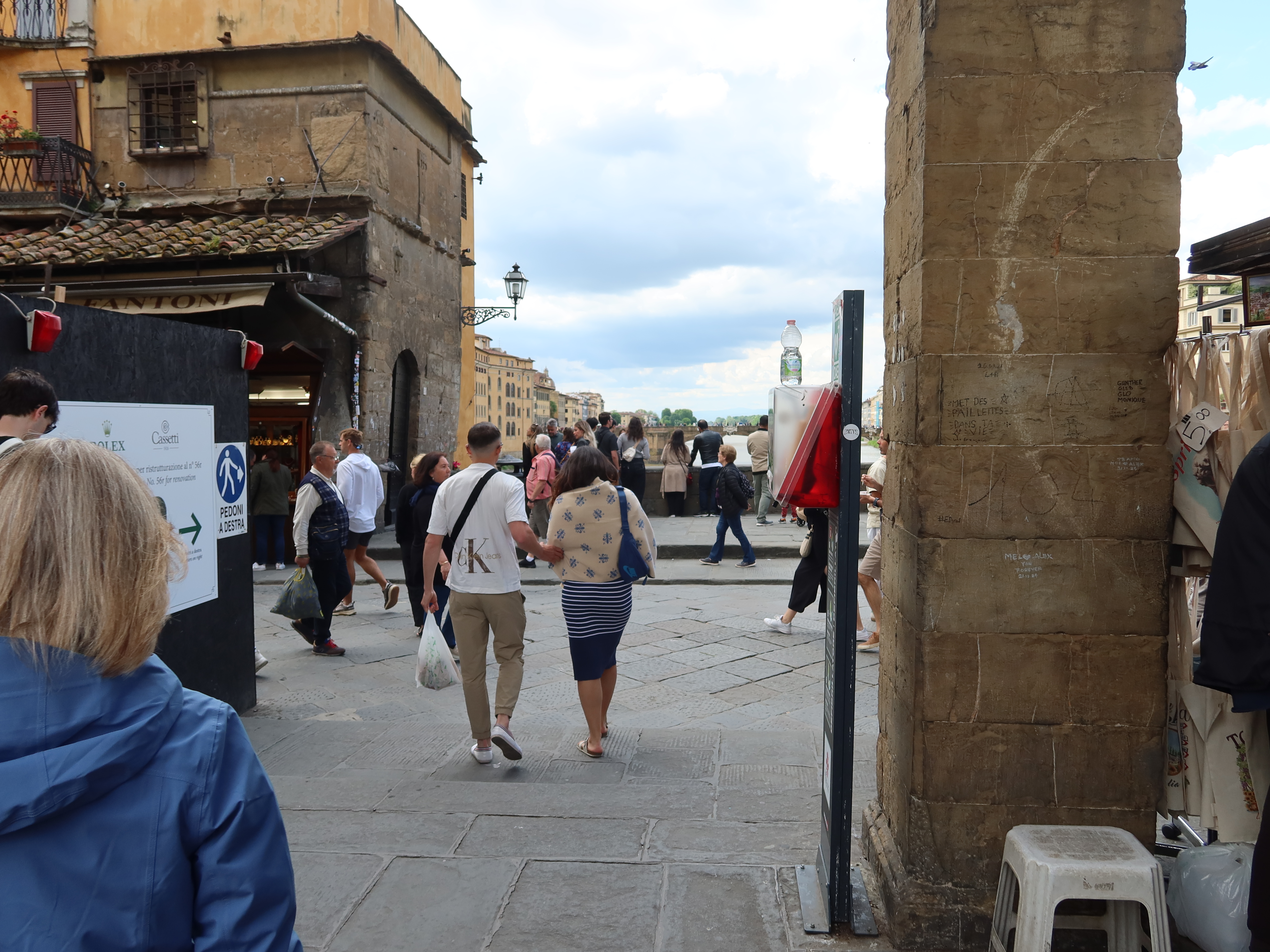 Historic Street Life Scene Busy street scene with people and historic architecture; stone building and pillar visible.